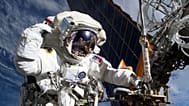 Astronauta da NASA e engenheira de voo da Expedição 72, Anne McClain surge junto de uma das principais matrizes solares da Estação Espacial Internacional
