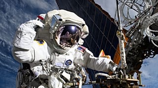 NASA astronaut and Expedition 72 Flight Engineer Anne McClain is pictured near one of the International Space Station’s main solar arrays.