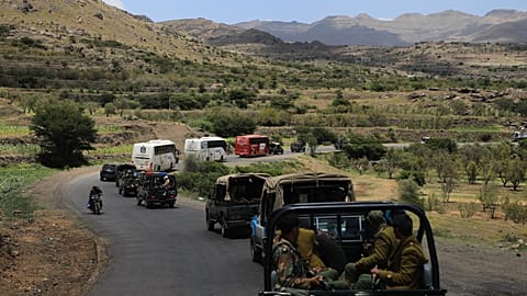 Houthi fighters escort a convoy carrying prisoners freed in Mokha through the Bani Matar district on its way to Sana'a, 12 September 2026