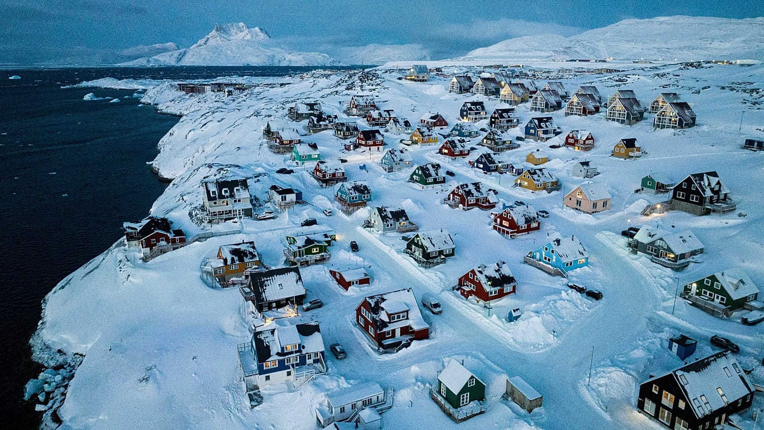 Houses covered in snow are seen on the coast of a sea inlet of Nuuk, Greenland, March 7, 2025.