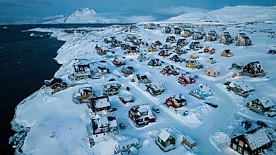Houses covered in snow are seen on the coast of a sea inlet of Nuuk, Greenland, March 7, 2025.
