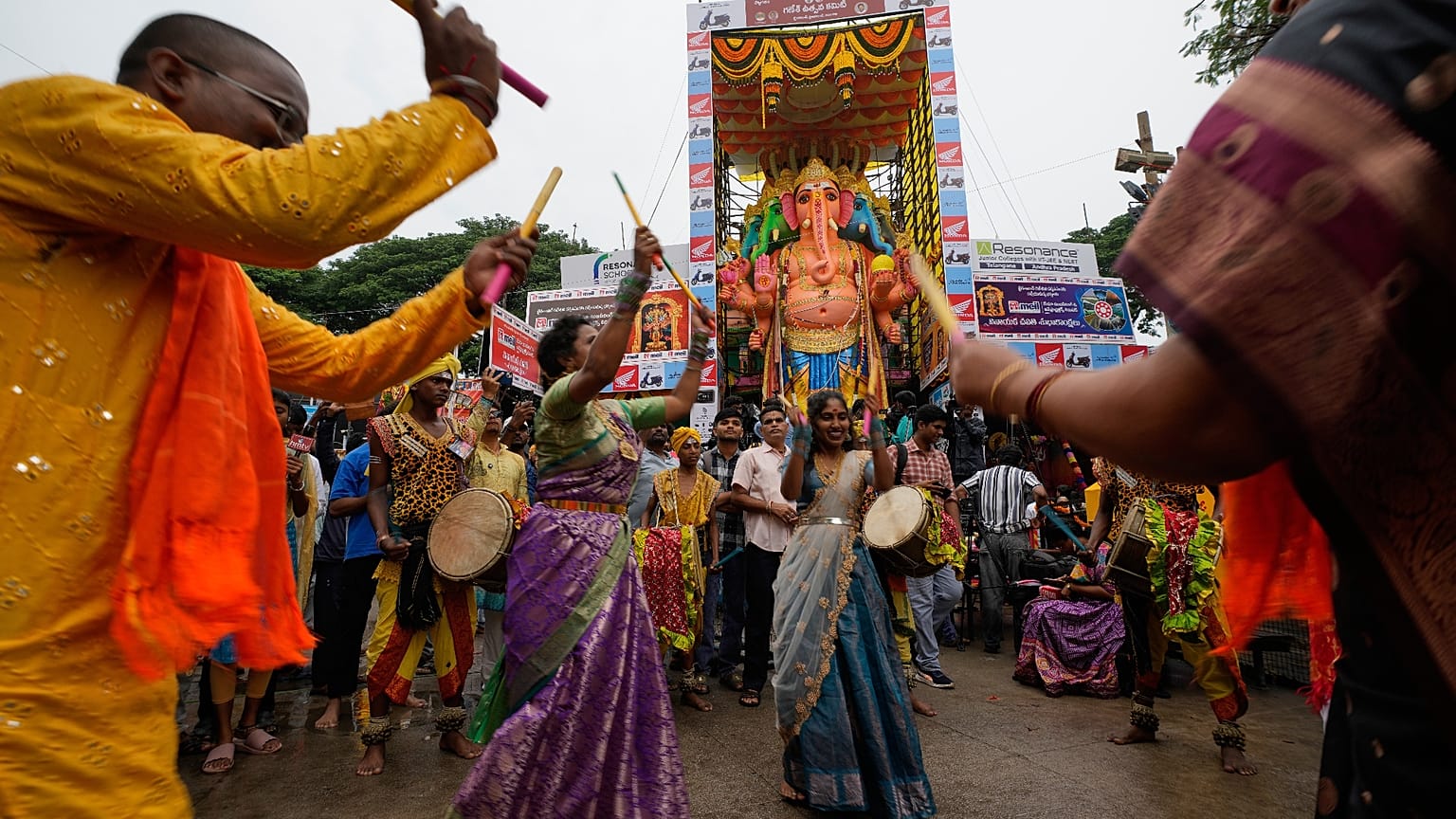Hindu hívők táncolnak, amikor megérkeznek, hogy imádják az elefántfejű Ganesát ábrázoló óriási szobrot a Ganésa Csaturthi ünnepen Hyderabadban