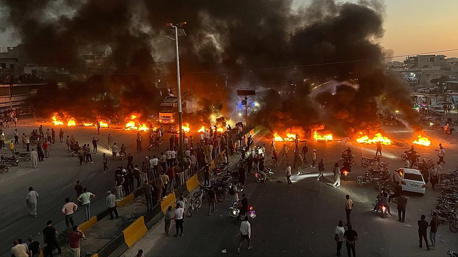 Protesters burn tyres and other debris to block a motorway, as demonstrations against soaring fuel prices spread across Syria.