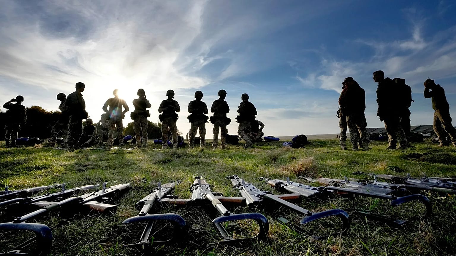 Weapons lie on the ground as Ukrainian personnel take a break during training at a military base with UK Armed Forces in Southern England, Wednesday, Oct. 12, 2022.