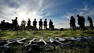 Weapons lie on the ground as Ukrainian personnel take a break during training at a military base with UK Armed Forces in Southern England, Wednesday, Oct. 12, 2022.
