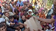 Vertriebene Familien, die vor den Überschwemmungen flohen, erhalten Hilfsgüter, die Soldaten der pakistanischen Rangers verteilen.