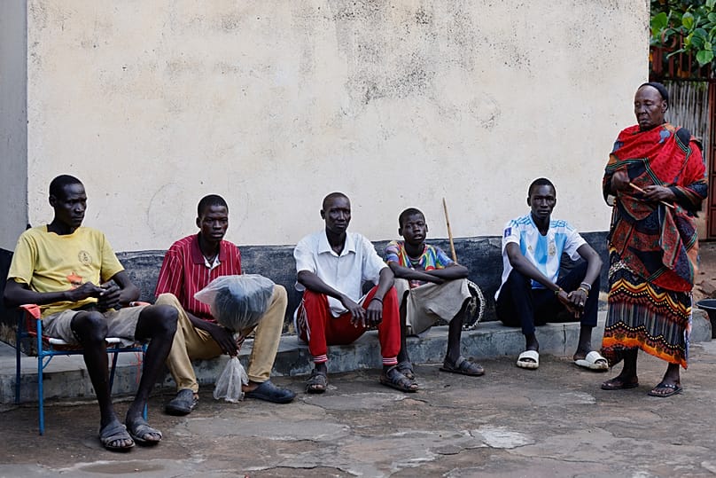 Young men and boys who fled drought in South Sudan sit alongside a chief in Torit, the capital of Eastern Equatoria state, South Sudan, Friday, Aug. 14, 2026.