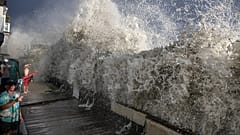 Une grosse vague déferle au-dessus d’un petit mur de soutènement près de maisons à Long Beach, Californie, dimanche 6 septembre 2026.