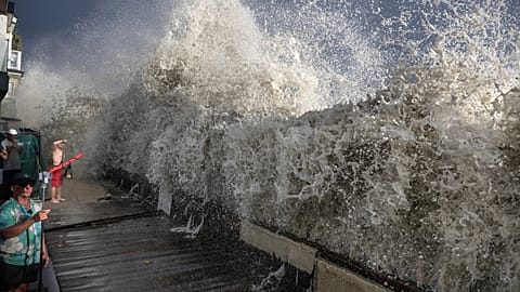 A large wave crashes up and over a small retaining wall near homes in Long Beach, Calif., Sunday, Sept. 6, 2026.