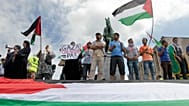 متظاهرون يلوحون بالعلم الفلسطيني خلال مسيرة مؤيدة لفلسطين في بروكسل، يوم الجمعة 25 يوليو/تموز 2014. (صورة من أسوشيتد برس/إيف لوغي)