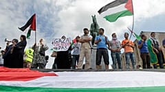 متظاهرون يلوحون بالعلم الفلسطيني خلال مسيرة مؤيدة لفلسطين في بروكسل، يوم الجمعة 25 يوليو/تموز 2014. (صورة من أسوشيتد برس/إيف لوغي)