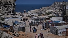 أشخاص يسيرون بمحاذاة خيام تؤوي فلسطينيين نازحين وسط أنقاض مبانٍ دمرتها غارات جوية إسرائيلية خلال الحرب مع حركة حماس، في مدينة غزة، يوم الاثنين 24 أغسطس 2026. (صورة من أسوشيتد 