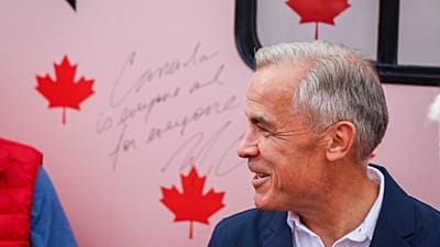Prime Minister Mark Carney smiles after signing the Forever Canadian bus following a cabinet retreat in Banff, Alta., Friday, Sept. 11, 2026.