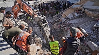 تبحث أطقم الدفاع المدني الفلسطينية عن جثث وناجين تحت أنقاض مبنى منهار كان يؤوي نازحين فلسطينيين وتعرض لأضرار بالغة خلال الحرب الإسرائيلية الحامية