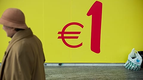 Woman walks past a supermarket in Lisbon, Portugal.