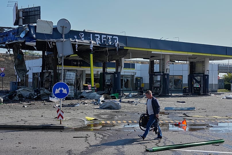 A worker leaves the damaged gas station after a Russian drone strike in Kyiv, Ukraine, Friday, Sept. 11, 2026. 