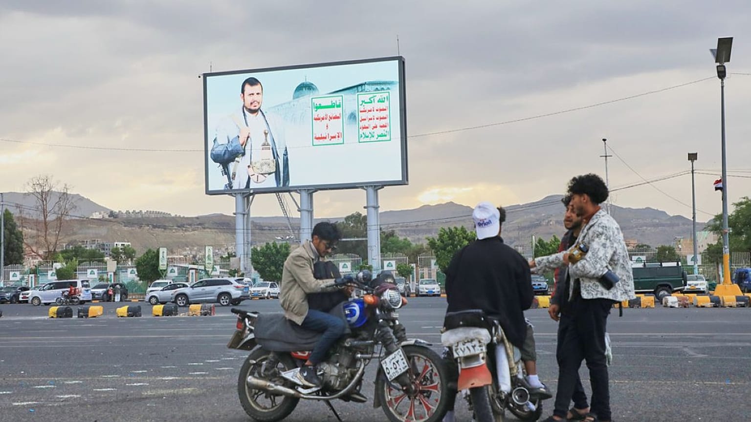 شباب يتجمعون أسفل لوحة إعلانية تحمل صورة زعيم الحوثيين عبد الملك الحوثي في ​​صنعاء، اليمن، يوم الثلاثاء، 15 سبتمبر 2026.