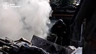 Emergency worker climbing through debris in Sumy