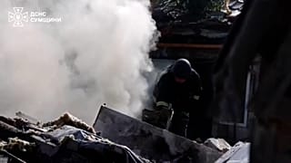Emergency worker climbing through debris in Sumy