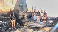 تُظهر هذه الصورة مقاتلين حوثيين يقفون ويهتفون فوق ما وصفته الجماعة بأنه حطام طائرة مقاتلة سعودية من طراز "إف-15" تحمل العلم السعودي