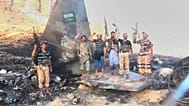 حوثی‌ها در یمن در کنار هواپیمای ساقط شده عربستان سعودی