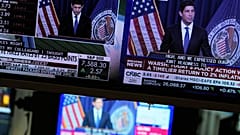 FILE. Screens display the news conference held by Federal Reserve chairman Kevin Warsh on the floor of the New York Stock Exchange, 16 Sept. 2026