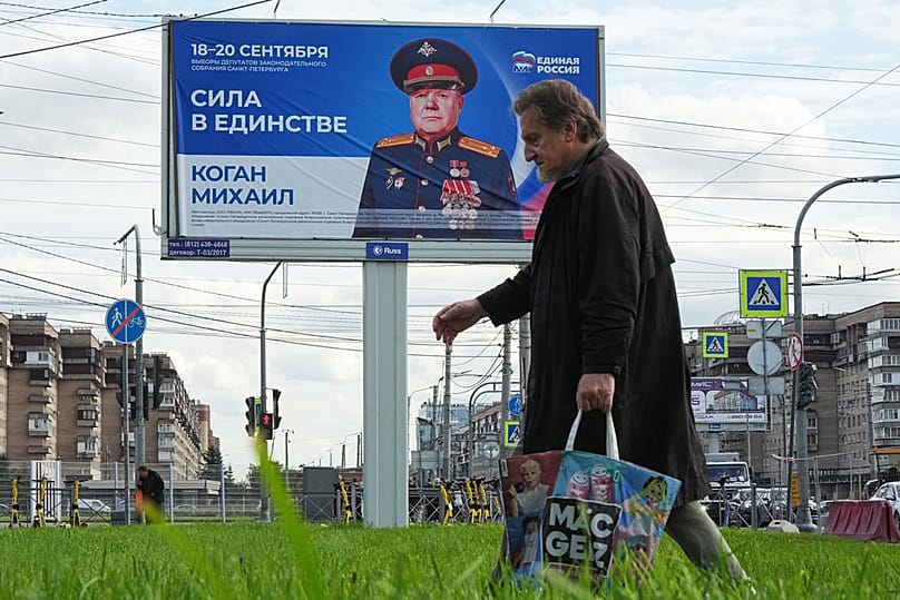 В Санкт-Петербурге мужчина проходит мимо рекламного щита, призывающего проголосовать за кандидата от партии «Единая Россия» 