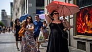  A woman holds an umbrella to shelter from the sun during a hot sunny day in Madrid, Spain, Monday, July 18, 2022.