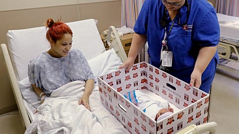 Keyshla Rivera smiles at her newborn son Jesus as registered nurse Christine Weick demonstrates a baby box before her discharge from Temple University Hospital in Philadelphia