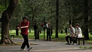 Ein Paar beobachtet eine Frau, die in einem Park nahe dem Himmelstempel in Peking Tai-Chi mit dem Schwert übt.