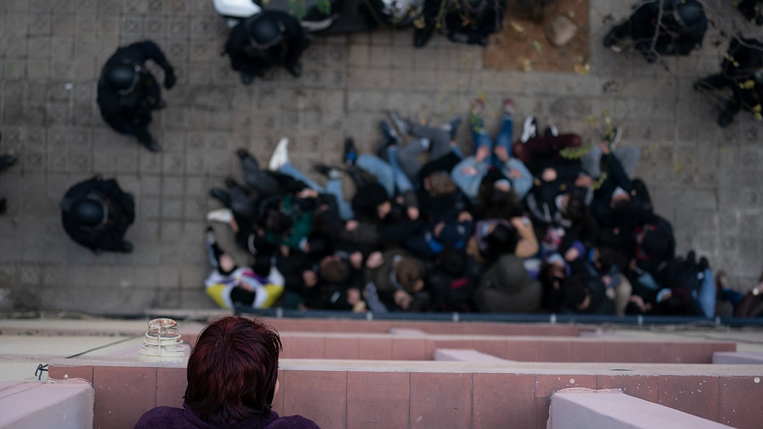 A woman watches from her window as police officers surround activists trying to stop the eviction of Alejandro Ibáñez Maltés in Barcelona in autumn 2020