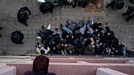 Uma mulher observa da janela agentes da polícia que cercam ativistas que tentam impedir o despejo de Alejandro Ibáñez Maltés em Barcelona, no outono de 2020