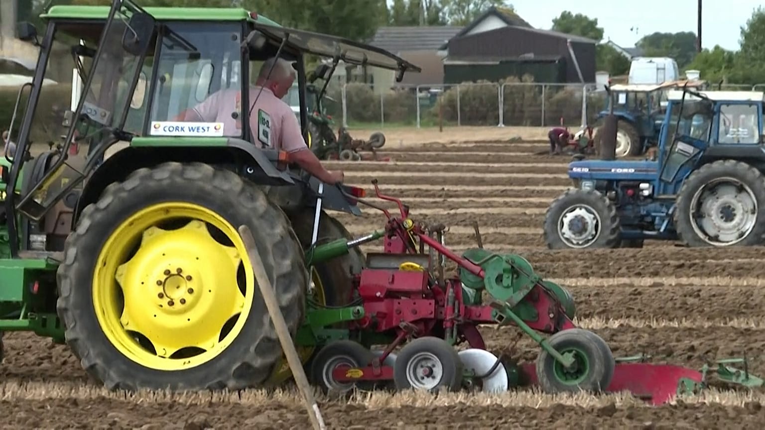 A farmer drives a tractor and plough at Ireland's National Ploughing Championships
