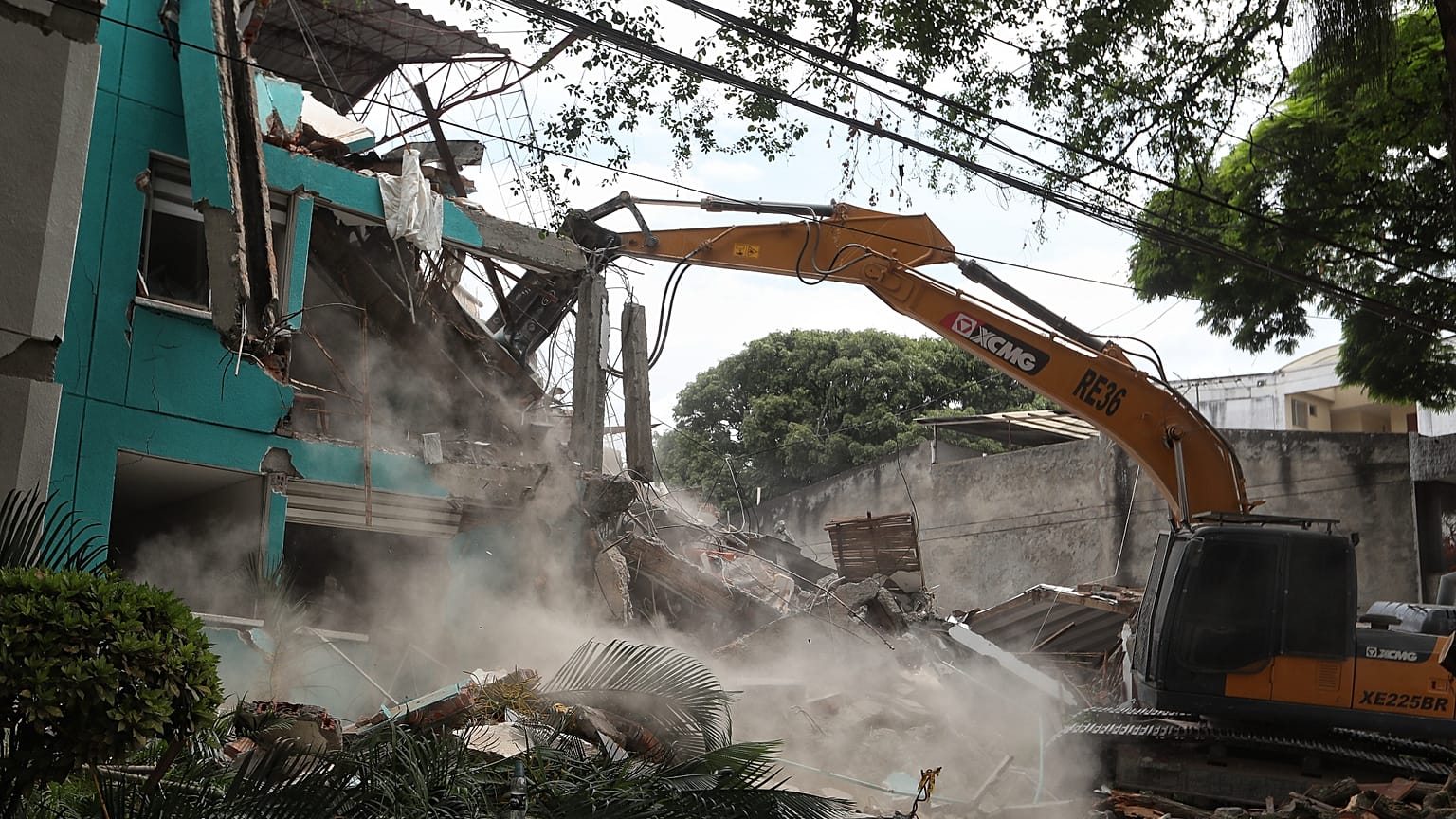 Una excavadora termina de derrumbar un edificio tras el terremoto de Colombia