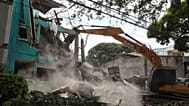 Una excavadora termina de derrumbar un edificio tras el terremoto de Colombia