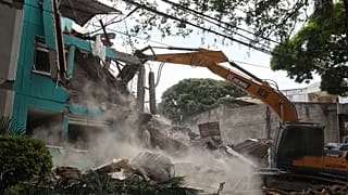 Una excavadora termina de derrumbar un edificio tras el terremoto de Colombia