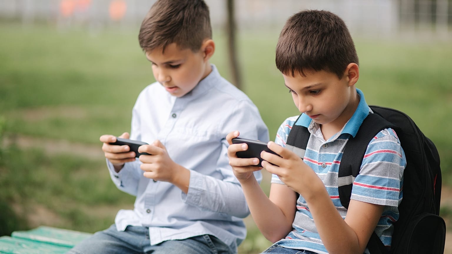 Two schoolchildren on their phones