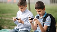Two schoolchildren on their phones