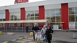 File - Customers walk after shopping in a store of the French retailer Auchan in St. Petersburg, Russia, Thursday, 24 Oct. 2024. 