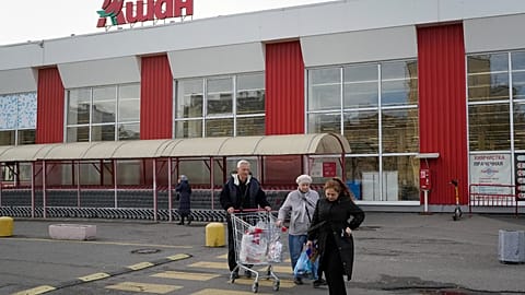 File - Customers walk after shopping in a store of the French retailer Auchan in St. Petersburg, Russia, Thursday, 24 Oct. 2024. 