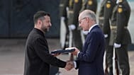 Ukrainian President Volodymyr Zelenskyy, left, hands over the Ukraine state award to Luxembourg's Prime Minister Luc Frieden, during a ceremony in Kyiv, Ukraine, Aug 24, 2026,