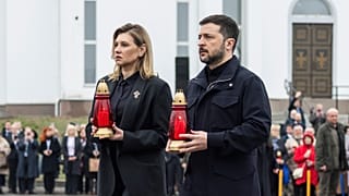 Volodymyr Zelenskyy and his wife Olena Zelenska carry candles to honour the memory of the victims of the Russian occupation  at a memorial in the town of Bucha.