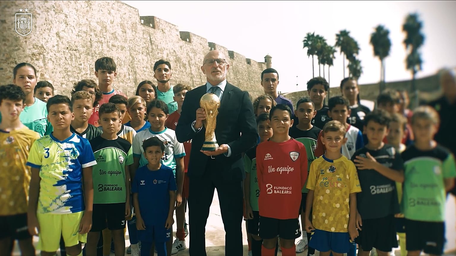 Luis de la Fuente sosteniendo el trofeo de campeones del mundo frente a un grupo de ceutíes 