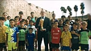 Luis de la Fuente sosteniendo el trofeo de campeones del mundo frente a un grupo de ceutíes 