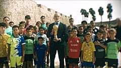 Luis de la Fuente sosteniendo el trofeo de campeones del mundo frente a un grupo de ceutíes 