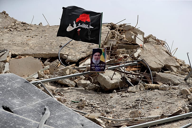 صورة للأمين العام السابق لحزب الله حسن نصرالله فوق منزل دمرته غارة إسرائيلية في بلدة عيتا الشعب جنوبي لبنان، 27 أيار 2024.