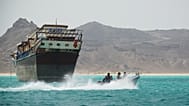 Pescatori yemeniti passano accanto a una nave commerciale nello strategico stretto di Bab el-Mandeb, Yemen, domenica 5 aprile 2026. (AP Photo/Abdulnasser Alseddik)