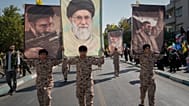 يحمل مشاركون يرتدون زياً موحداً صورةً للمرشد الأعلى الإيراني مجتبى خامنئي خلال عرض عسكري الطابع نظمته الدولة تحت شعار "التضحية من أجل إيران"