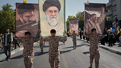 يحمل مشاركون يرتدون زياً موحداً صورةً للمرشد الأعلى الإيراني مجتبى خامنئي خلال عرض عسكري الطابع نظمته الدولة تحت شعار "التضحية من أجل إيران"