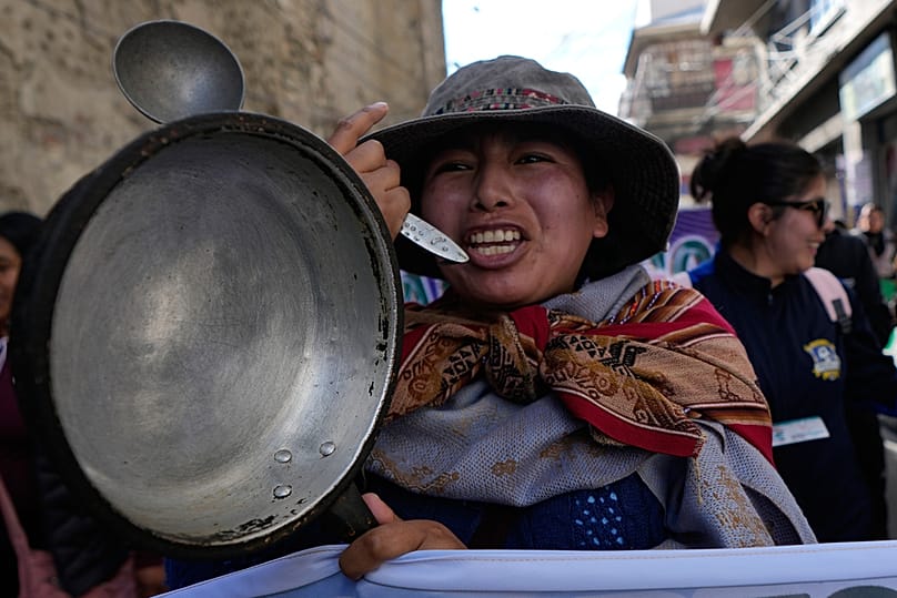 A teacher holds an empty pot during an anti-government protest in La Paz, Bolivia, Tuesday, Sept. 15, 2026